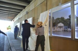 A group of people standing in front of a wall with a picture on it.