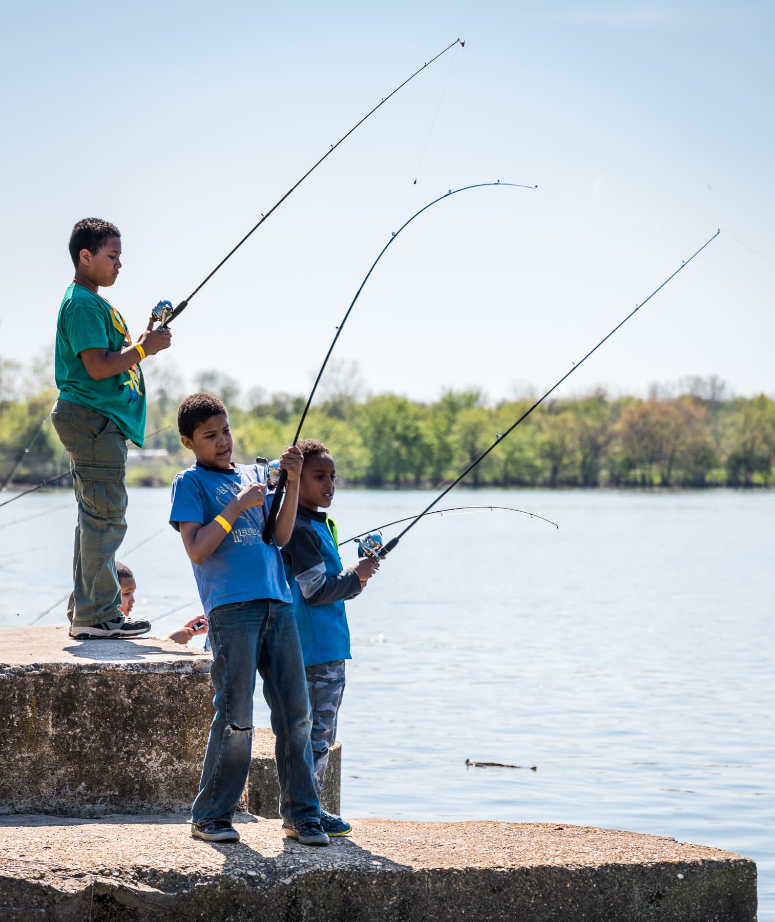 A group of kids fishing in a lake.