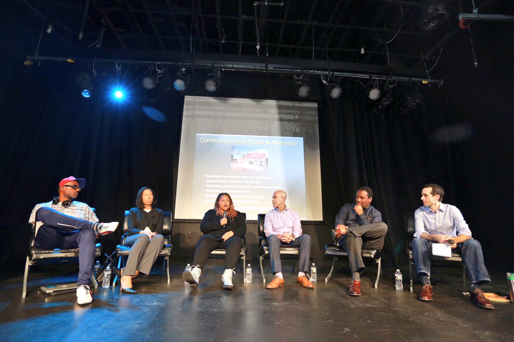 A group of people sitting on chairs on a stage.