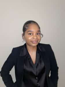 A young woman in a black blazer posing for a photo.
