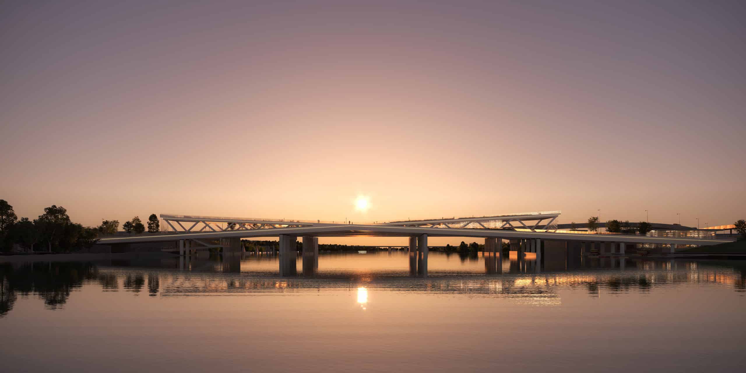 A bridge over a body of water at sunset.