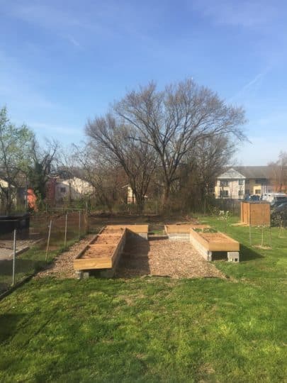 A backyard with a raised garden bed in Bridge Park Plots, cultivating urban farms & gardens for community growth.