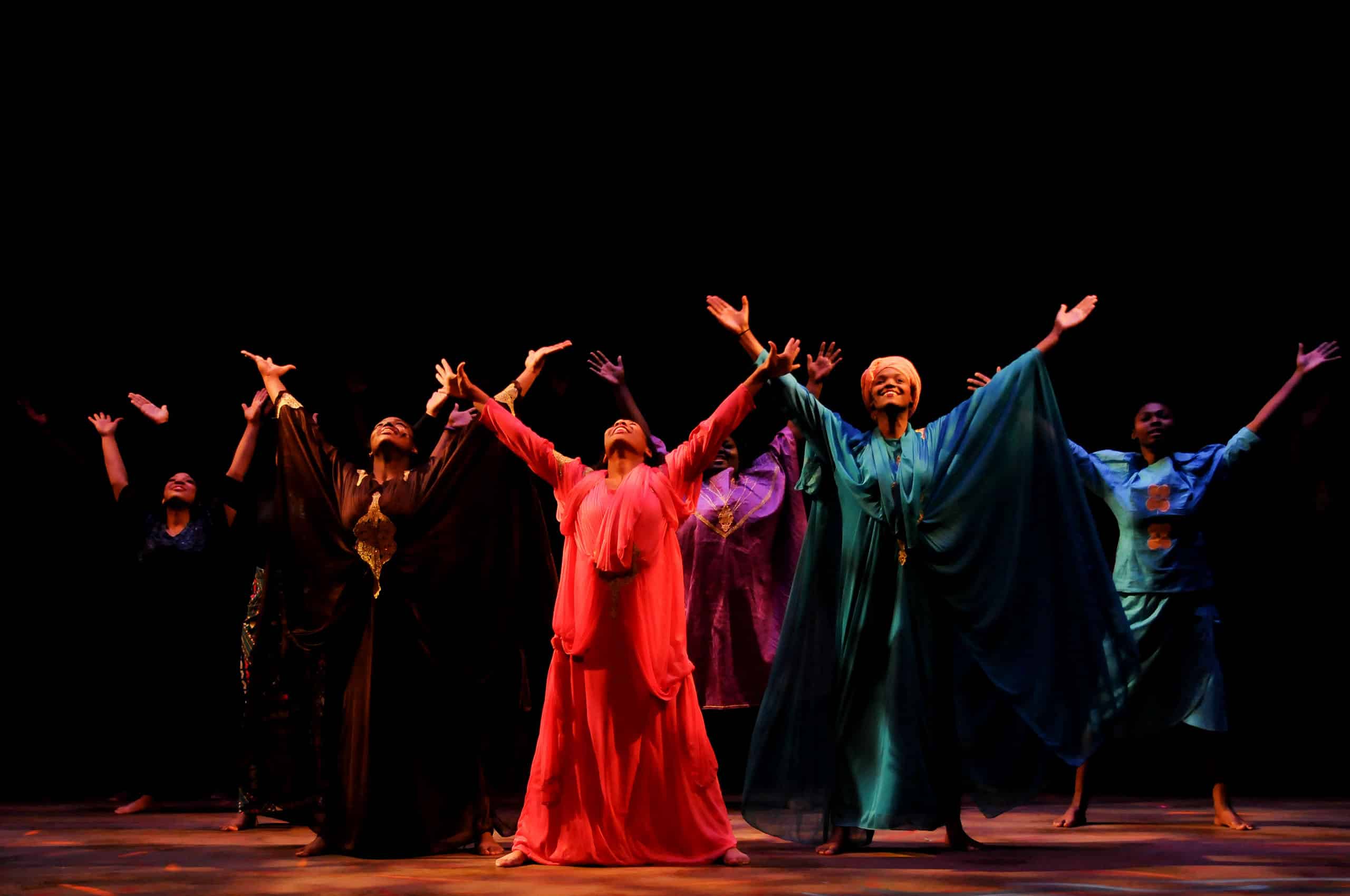 A group of women with their arms outstretched on THEARC Theater stage, promoting Arts & Community Engagement.
