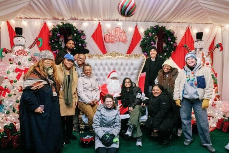 A group of people posing for a photo with santa claus.