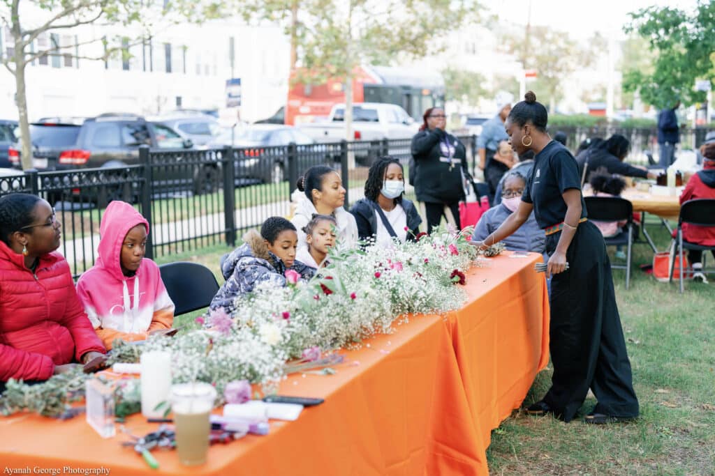 A group of people standing around a table with flowers.