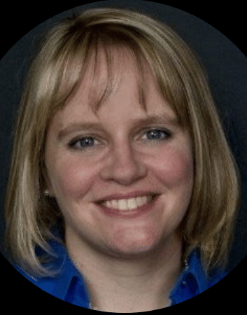 A woman with shoulder-length blonde hair and blue eyes, wearing a blue shirt, smiles at the camera, embodying the spirit of Building a Better Future with the 11th Street Bridge Park Team - Bridging Communities.