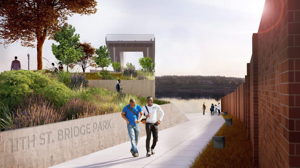 The pathway, flanked by people enjoying the landscaped garden and brick wall, tells a story of community-driven design. In the background, a bridge spans the river under a cloudy sky—a testament to building bridges across the river and uniting people with nature.